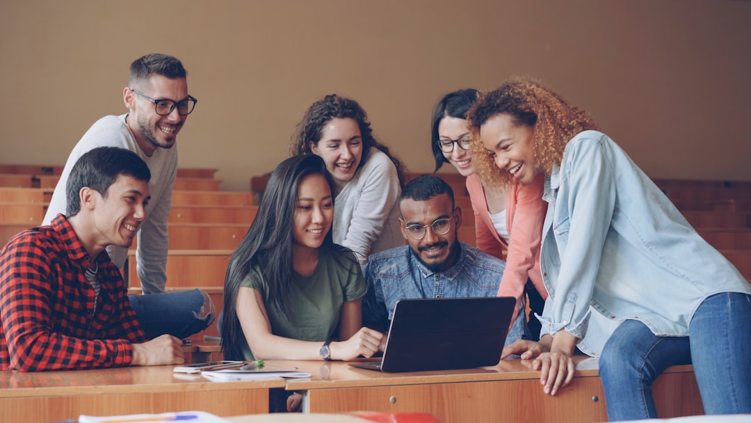 Grupo diverso trabajando con laptop, útil para un artículo sobre desarrollo web para escuelas y colegios hispanos en USA